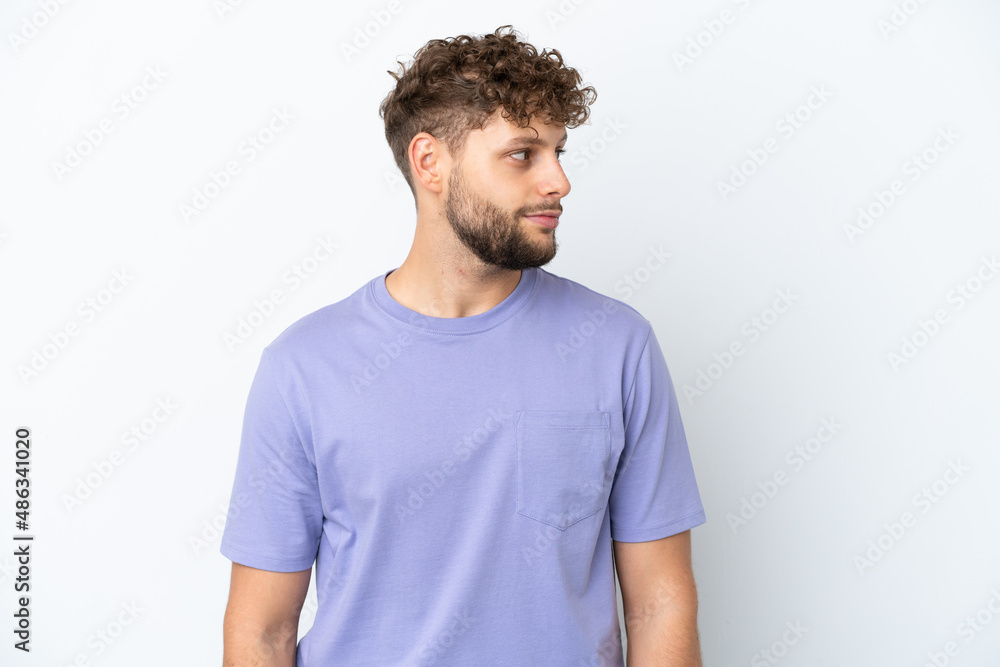 Fototapeta premium Young handsome caucasian man isolated on white background looking to the side