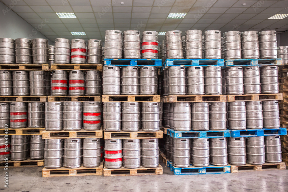 Brewery, bottling beer on aluminum kegs on conveyor lines. Industrial work, automated modern food and beverage production. Brewery, bottling beer on aluminum kegs on conveyor lines. Industrial work, automated modern food and beverage production.