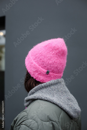 
Woman wearing a homemade cerise hat in hot pink or fuchsia on a gray background