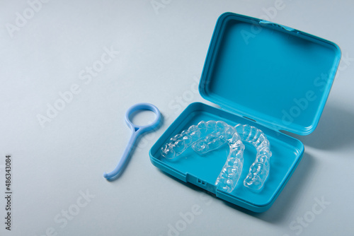 Container with plastic mouthguards on a blue background