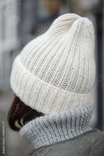  Close-up shot of a handmade knitted wool hat in white color. Fashionable actual hat for the autumn-winter-spring season. Alpaca wool
