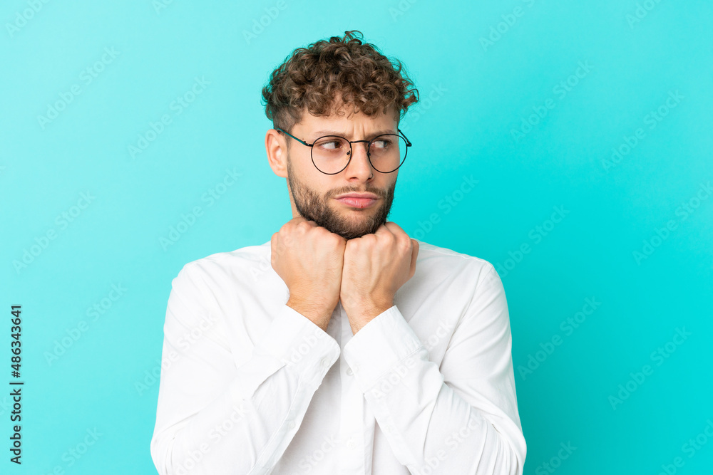 Young handsome caucasian man isolated on blue background With glasses and tired Young handsome caucasian man isolated on blue background With glasses and tired