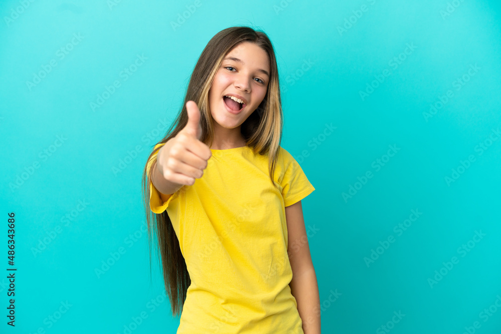 Fototapeta premium Little girl over isolated blue background with thumbs up because something good has happened