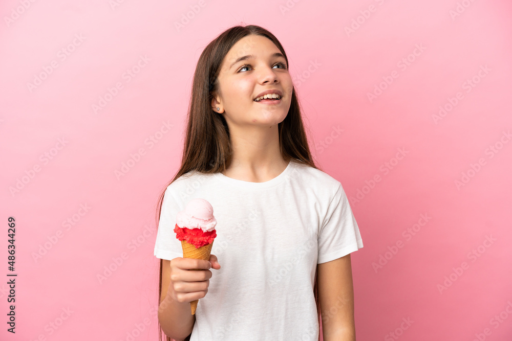 Little girl with a cornet ice cream over isolated pink background laughing Little girl with a cornet ice cream over isolated pink background laughing