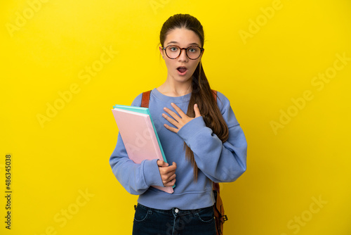 Student kid woman over isolated yellow background surprised and shocked while looking right