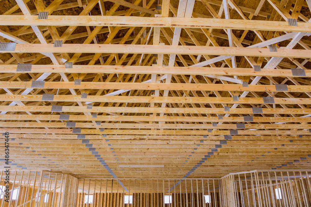 Roof framing wood beams of wooden building new stick built home under construction Roof framing wood beams of wooden building new stick built home under construction