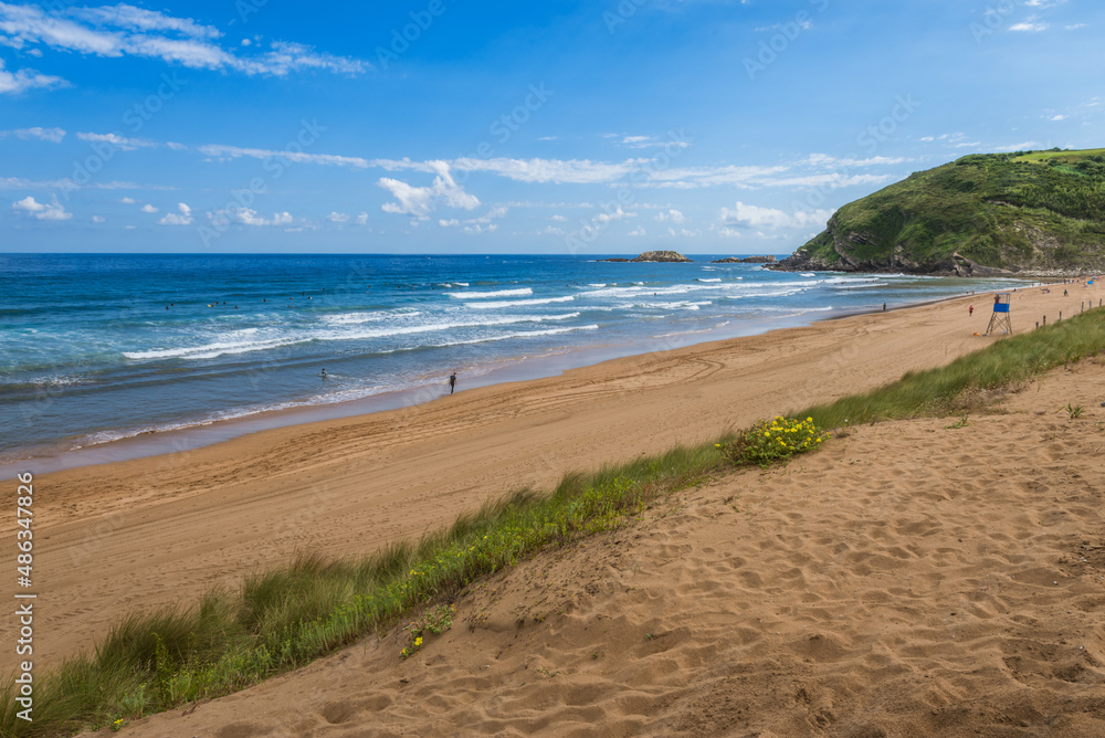 View to the Zarautz Beach with walking people, Basque Country, Spain on a beautiful summer day View to the Zarautz Beach with walking people, Basque Country, Spain on a beautiful summer day