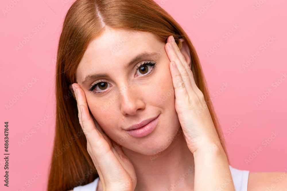 Young redhead woman isolated on pink background Young redhead woman isolated on pink background