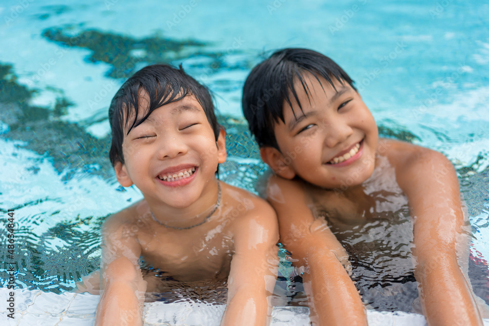 Asian Young Boy Brother Having a Good Time Playing and Enjoying in Swimming Pool Together in Summer Asian Young Boy Brother Having a Good Time Playing and Enjoying in Swimming Pool Together in Summer