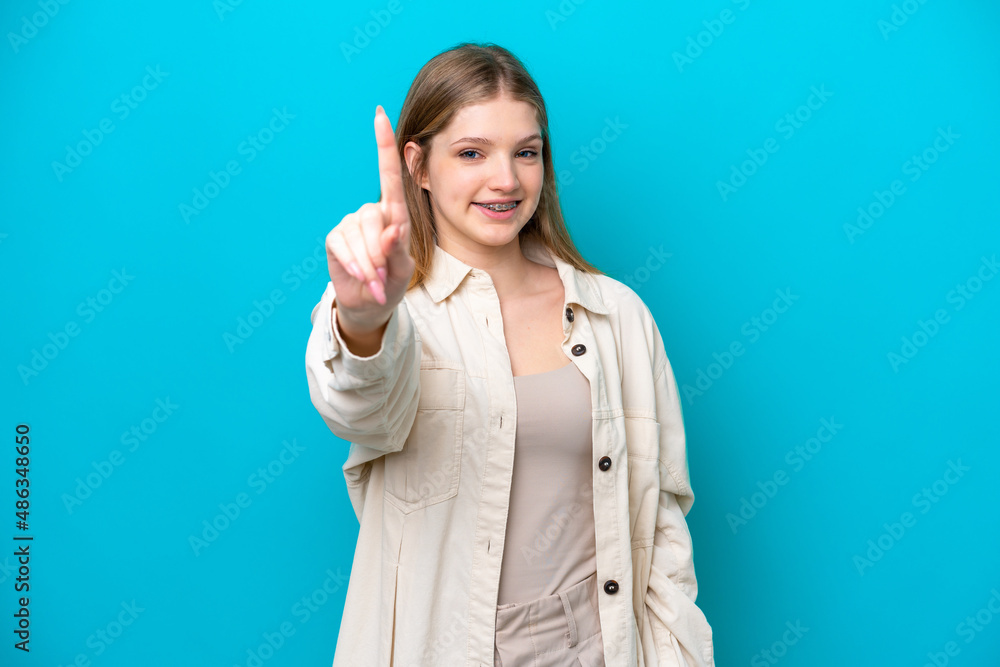 Teenager Russian girl isolated on blue background showing and lifting a finger Teenager Russian girl isolated on blue background showing and lifting a finger