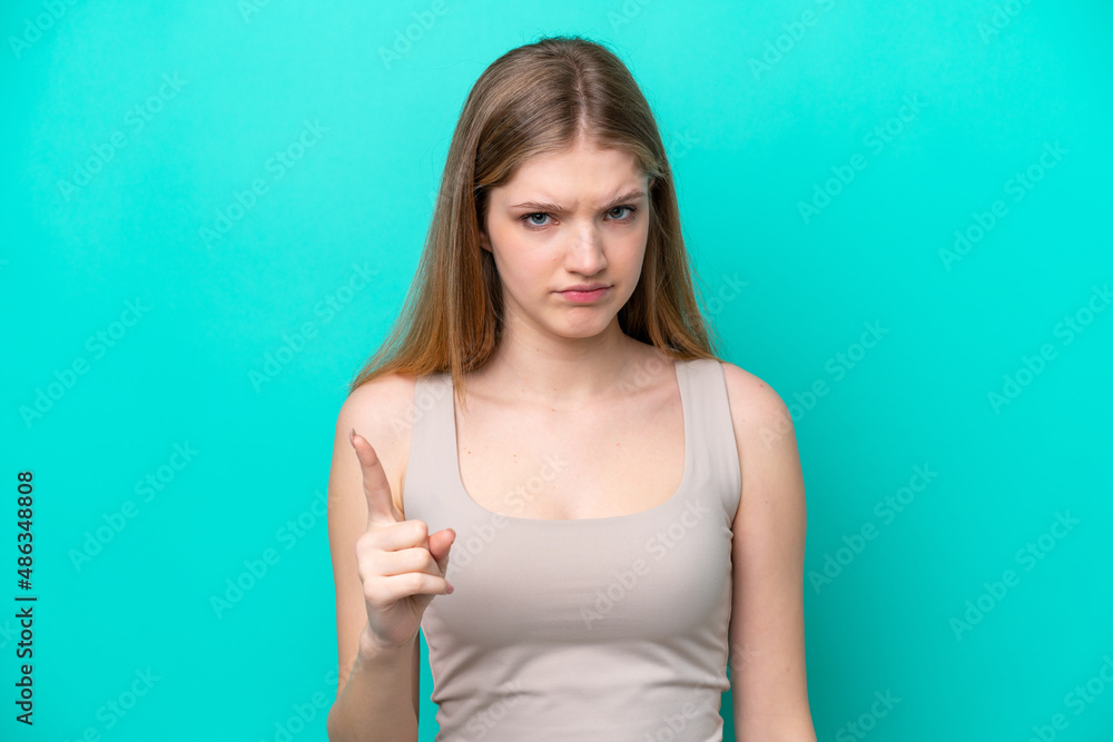 Teenager Russian girl isolated on blue background frustrated and pointing to the front Teenager Russian girl isolated on blue background frustrated and pointing to the front