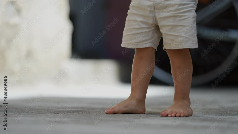 Child legs walking outside barefoot wearing shorts Child legs walking outside barefoot wearing shorts