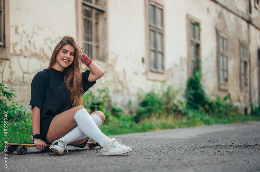 Fototapeta premium Young woman sitting on her longobard on the road
