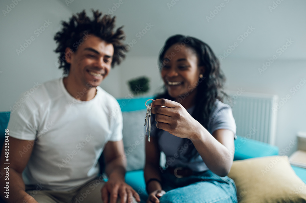 African american couple holding home keys in their new apartment