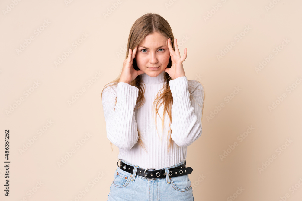 Teenager Ukrainian girl isolated on beige background with headache Teenager Ukrainian girl isolated on beige background with headache