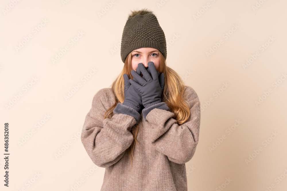 Obraz premium Teenager Ukrainian girl with winter hat isolated on beige background with surprise facial expression