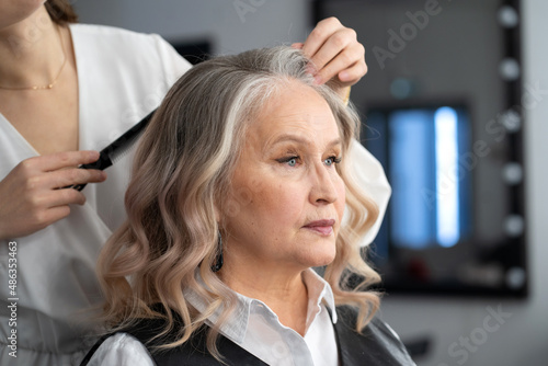 Elderly woman getting make-up and styling in a beauty salon
