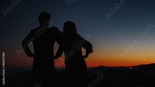 Silhouette of boy and girl hug each other at sunset 