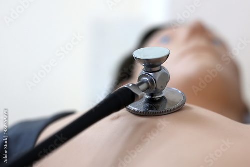 medical manikin for auscultation of the heart and lungs, manikin and stethoscope photo