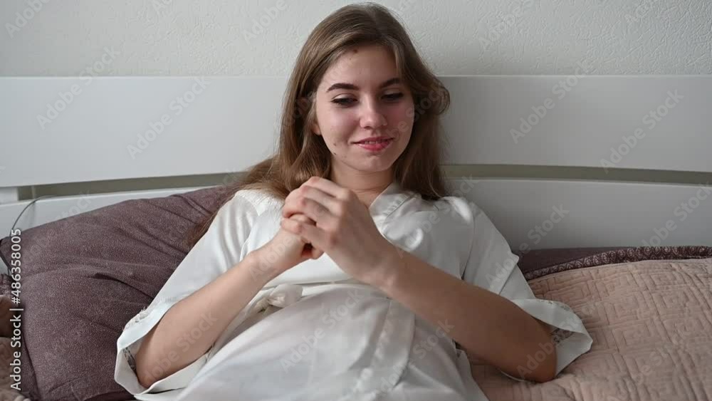a girl with problematic hair sits on the bed and combs them. girl with a comb sits on a bed in pajamas a girl with problematic hair sits on the bed and combs them. girl with a comb sits on a bed in pajamas
