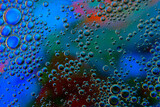 Bubbles in oil in water on blue, turquoise and purple colour abstract background