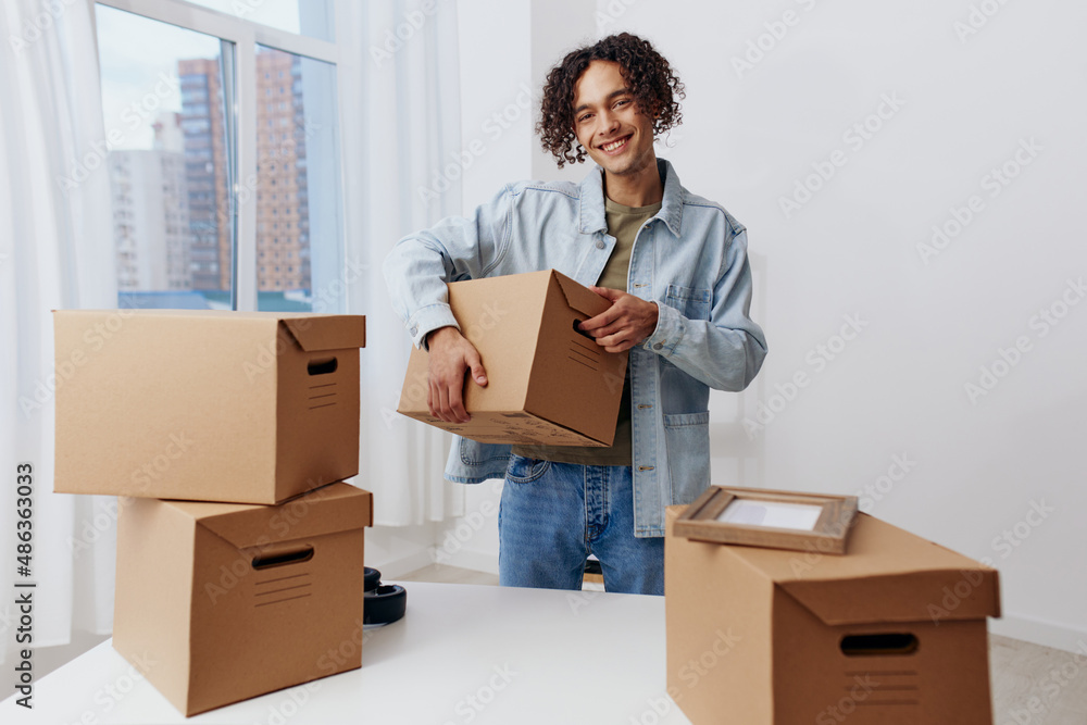 handsome guy unpacking things from boxes in the room Lifestyle handsome guy unpacking things from boxes in the room Lifestyle