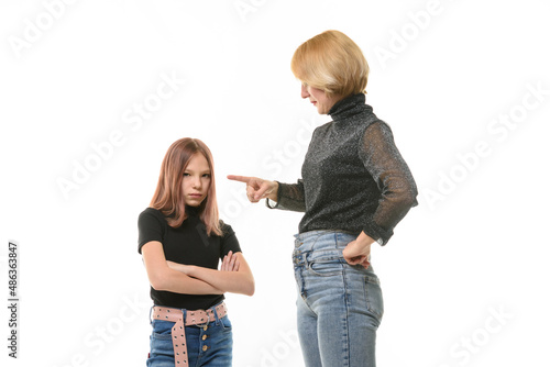 Woman scolding her daughter, upset daughter looks into the frame, close-up portrait