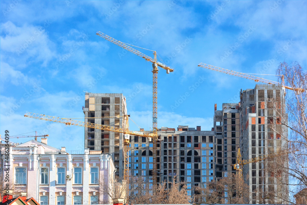 Construction of a modern high-rise residential building against the backdrop of old urban architecture.