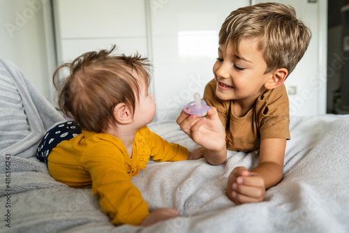 Принти на полотні Small caucasian boy five years old lying on the bed with his baby brother or sis