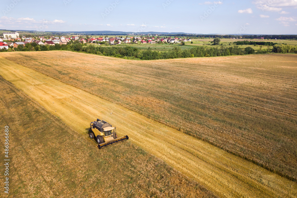 Aerial view of combine harvester harvesting large ripe wheat field. Agriculture from drone view Aerial view of combine harvester harvesting large ripe wheat field. Agriculture from drone view