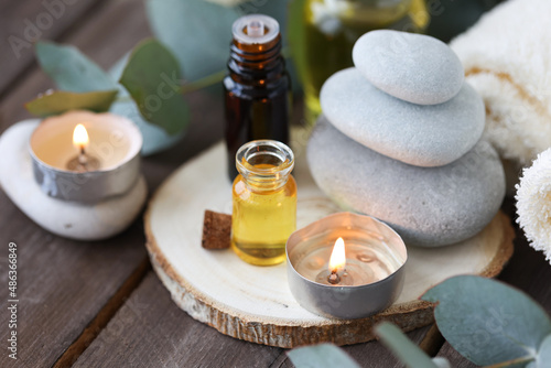 Assortment of natural oils in glass bottles on wooden background. Concept of pure organic ingredients in cosmetology. Bath accessoiries  atmosphere of harmony  relax. Close up macro. Healthy lifestyle