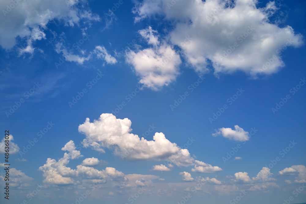 Obraz premium Bright landscape of white puffy cumulus clouds on blue clear sky