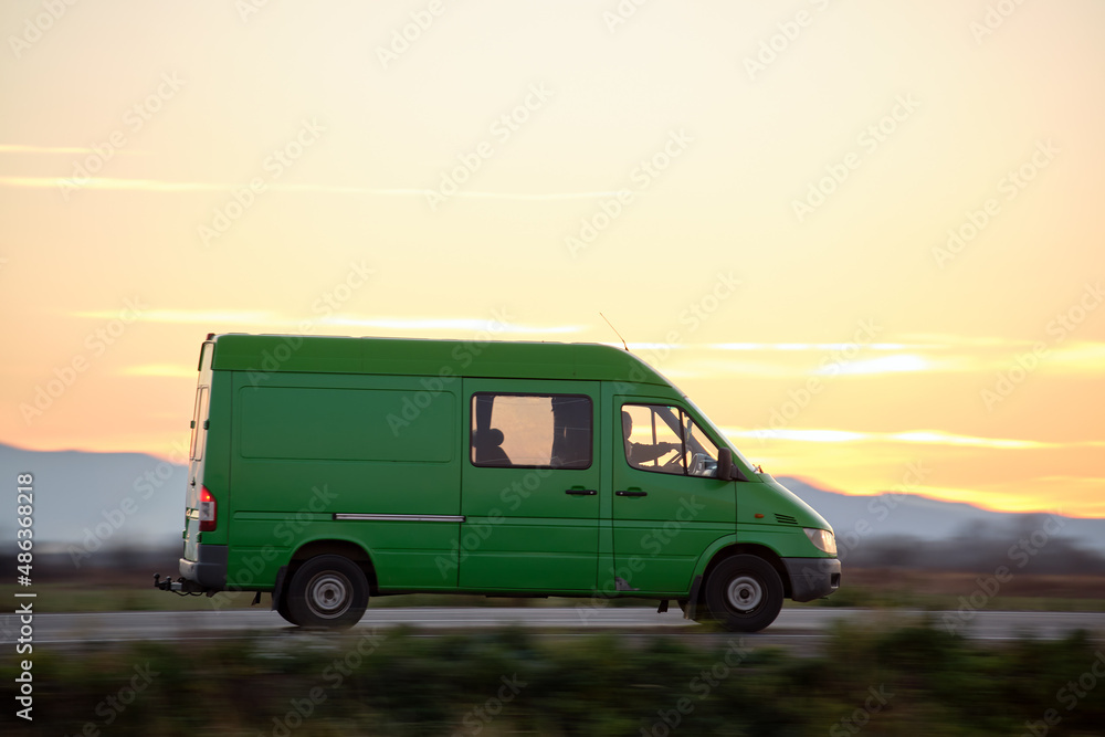 Small cargo van driving on highway hauling goods. Delivery transportation and logistics concept