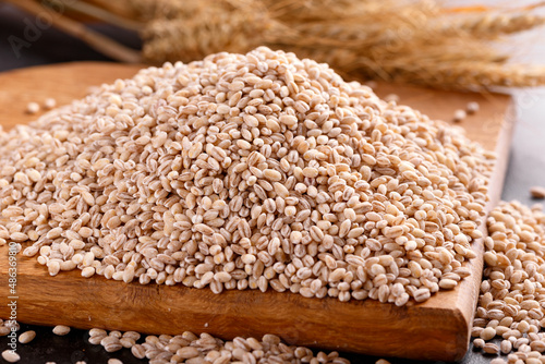 Raw organic Pearl barley on wooden board