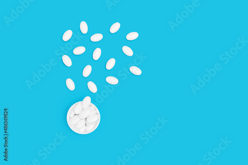White pills for treatment on blue background  pharmacy and medicine concept  top view