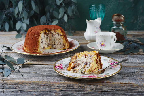 Traditional Italian Panettone cake stuffed with ricotta pudding, glanced fruits and raisins served as close-up on a classic design plate photo