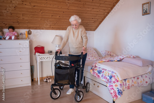 Handicapped senior woman with rollator walker at home