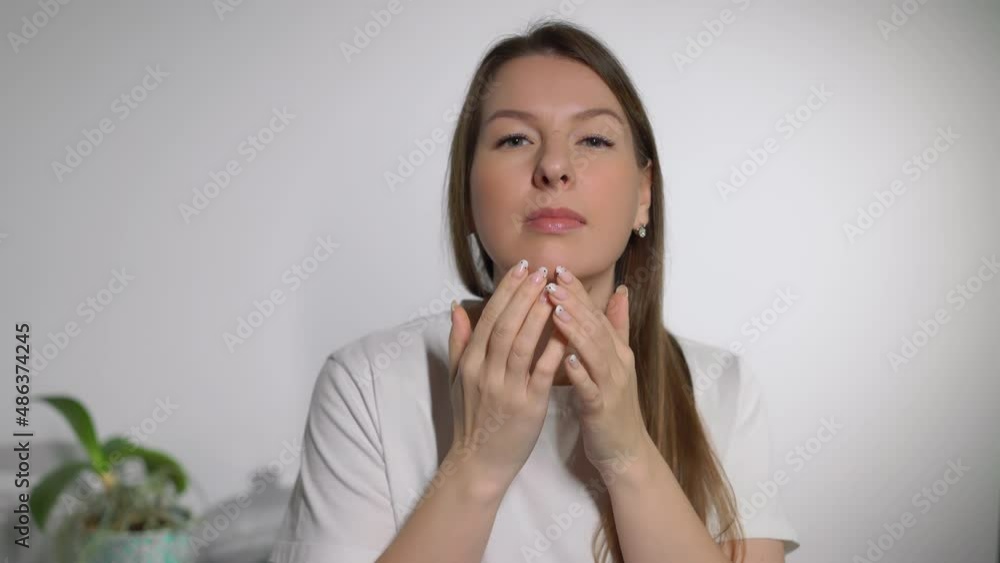 A young woman looks in the mirror. Beautiful girl is going, looking at skin. A young woman looks in the mirror. Beautiful girl is going, looking at skin.