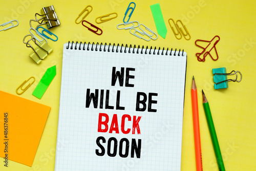 WE'LL BE BACK SOON text on paper with calculator,magnifier ,pen on graph background