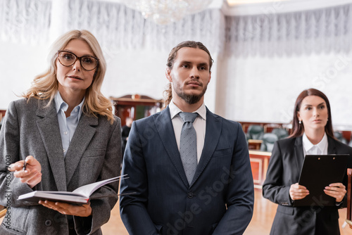 Quadro su tela accused businessman standing near advocate and prosecutor in court