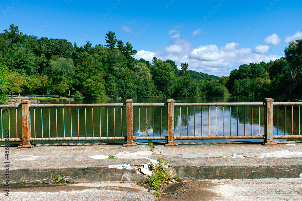 Rusted Fence on a cracked bridge with landscape in background Rusted Fence on a cracked bridge with landscape in background
