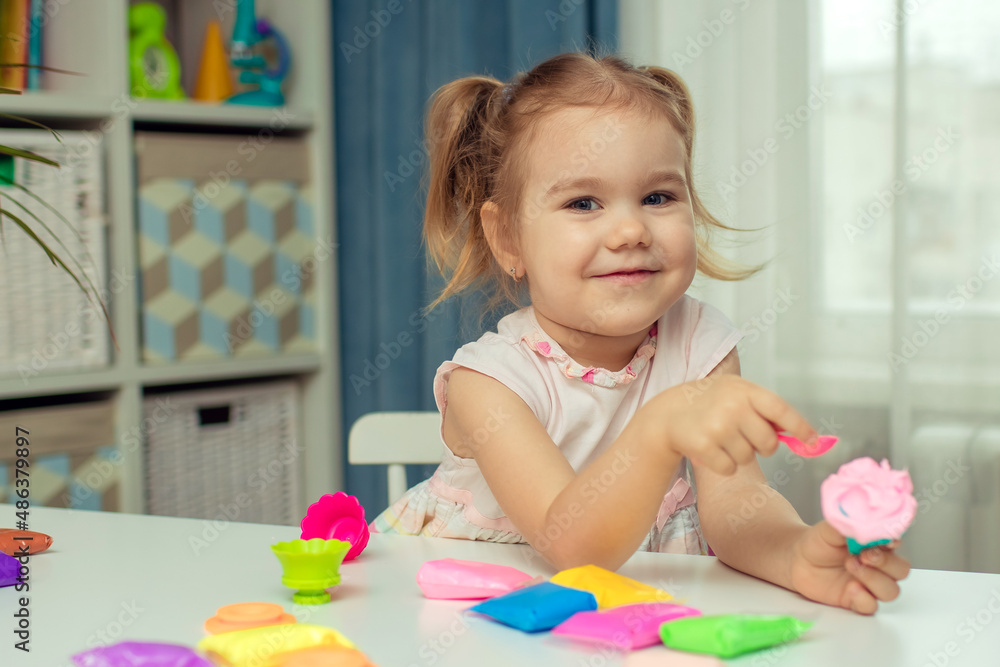 Happy little girl sculpts plasticine and learns. Happy little girl sculpts plasticine and learns.