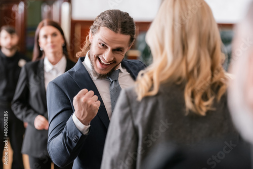 Foto selective focus of excited businessman showing win gesture near advocate and pro