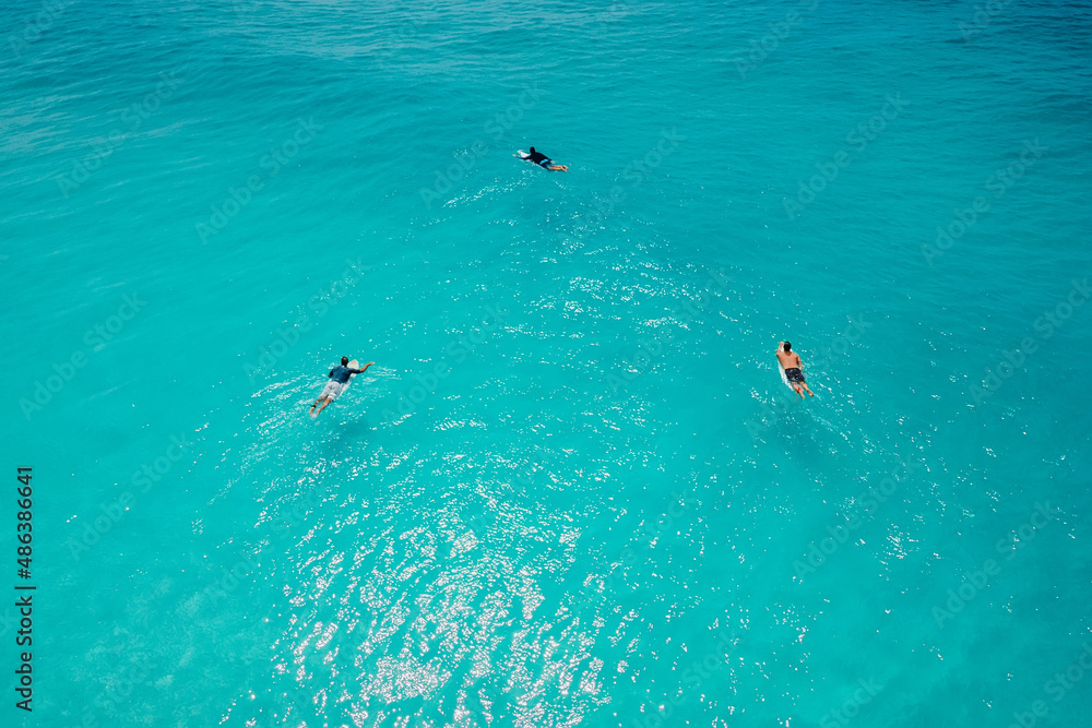 Surfers on surfboards in ocean waiting wave. Aerial view