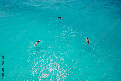 Surfers on surfboards in ocean waiting wave. Aerial view