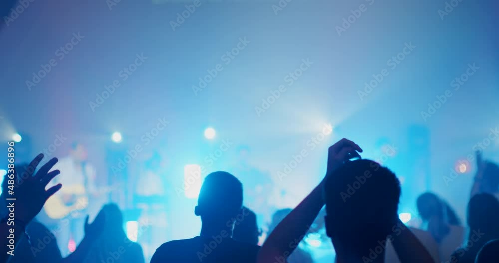 Rock or Pop Band Concert with Crowds of Dancing, Jumping and Applauding People. Live Music Festival or Night Event Party with Light Show Performance. Blurred 4K handheld shot in slow motion