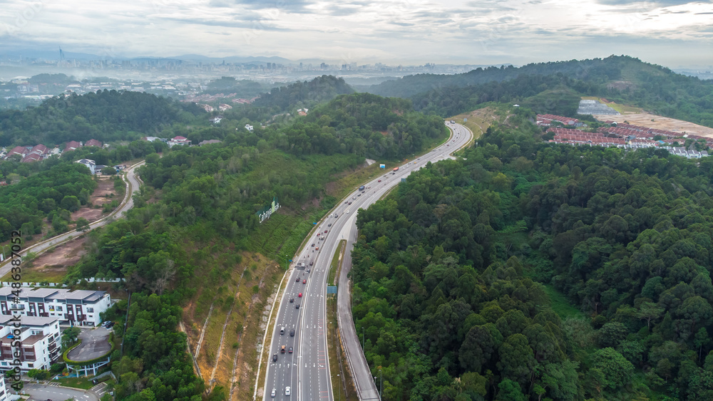 Aerial view of residential area with green asphalt road and residential houses directly above viewpoint. View of suburbs and city district. Real estate and housing market concept.