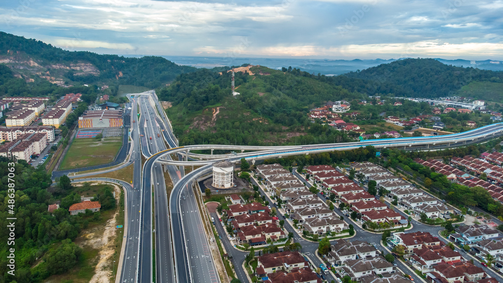 Aerial view of residential area with green asphalt road and residential houses directly above viewpoint. View of suburbs and city district. Real estate and housing market concept. Aerial view of residential area with green asphalt road and residential houses directly above viewpoint. View of suburbs and city district. Real estate and housing market concept.