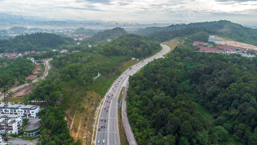 Aerial view of residential area with green asphalt road and residential houses directly above viewpoint. View of suburbs and city district. Real estate and housing market concept.