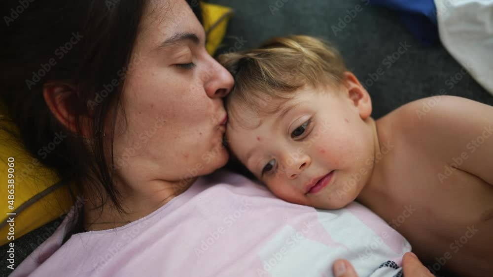 Mother and child lying on sofa showing love and affection Mother and child lying on sofa showing love and affection